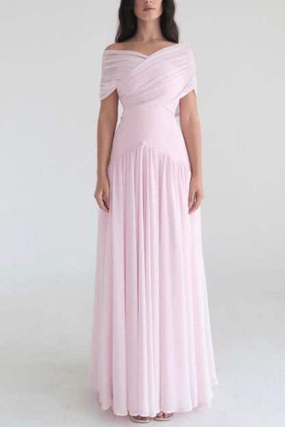 Detail van de roze maxi jurk met off-shoulder halslijn en zachte stof