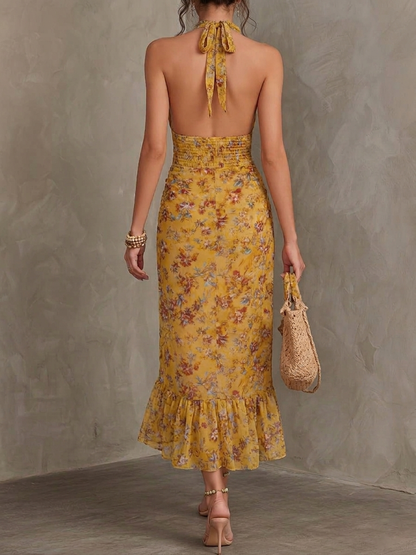 Gele midi jurk met bloemenprint en halterhals gedragen door model