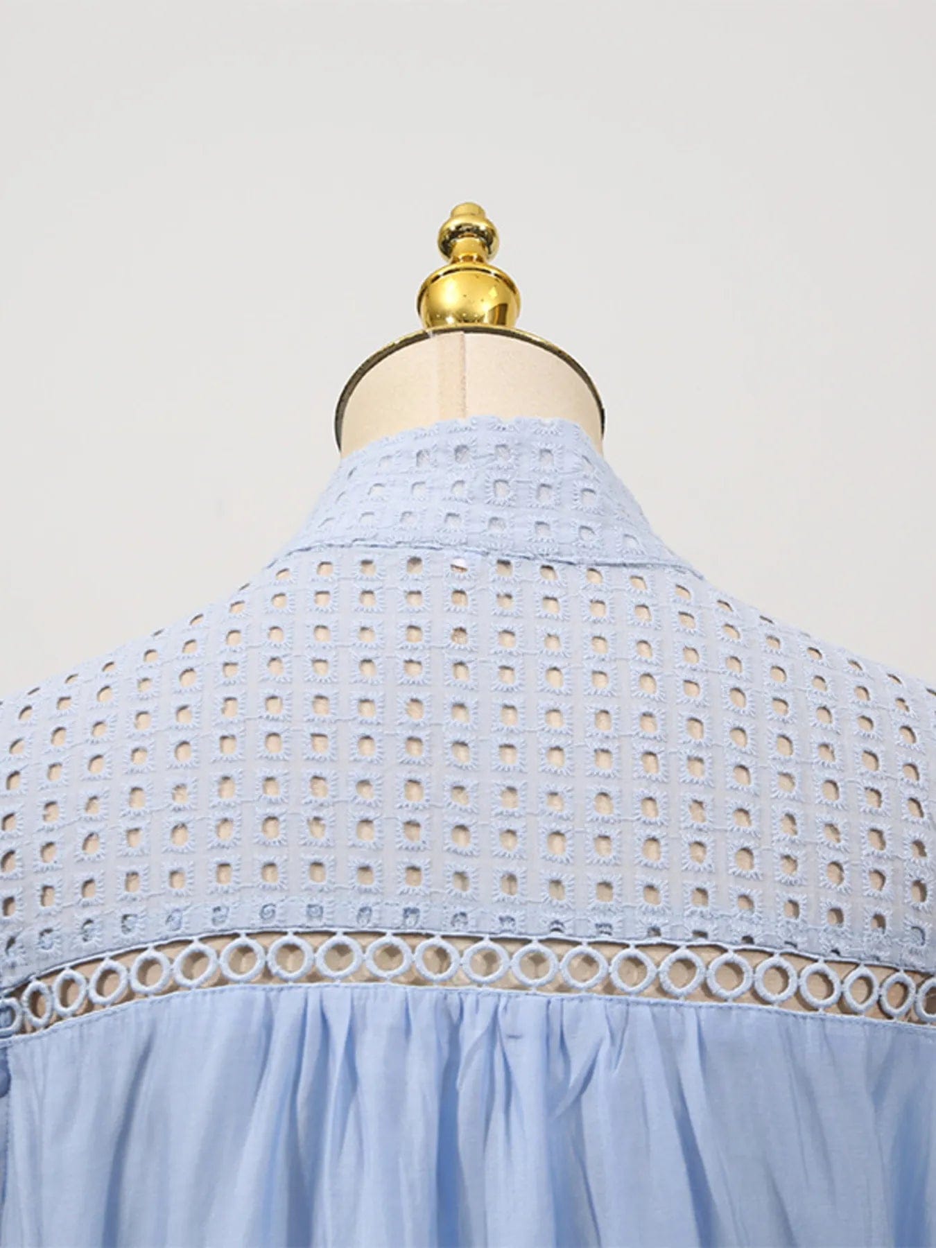 Mouwloze midi-jurk met oogjesstof en open details