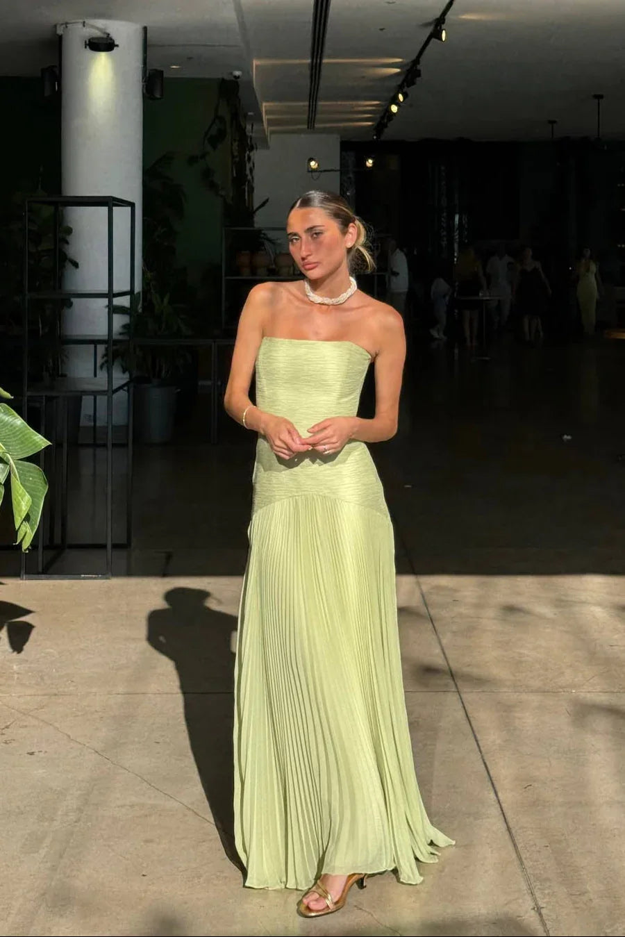 Zijaanzicht van een elegante geplooide strapless avondjurk